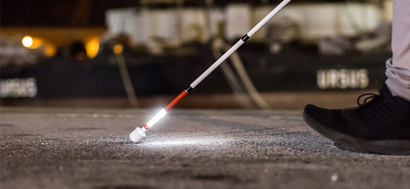 Persona usa di notte in strada il bastone bianco luminoso LETIsmart