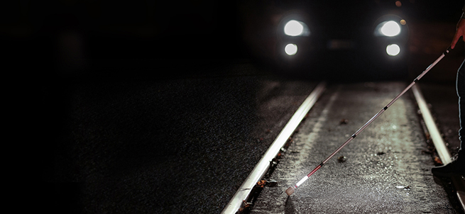 Persona attraversa la strada di notte con bastone bianco luminoso LETIsmart
